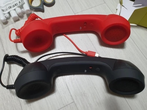 Dos auriculares retro, rojo y negro, recién sacados de la caja